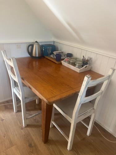 a wooden table with two chairs in a kitchen at 4 Lisle court cottages in Lymington