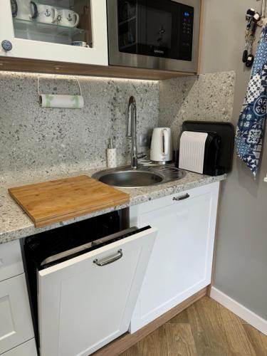 a kitchen with a sink and a microwave at Apartament Nocuj w Rowach in Rowy