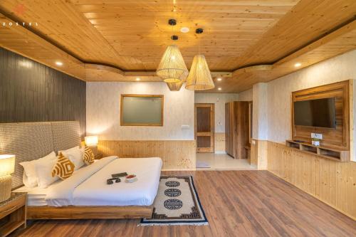 a bedroom with a bed and a flat screen tv at Zostel Old Manali, Goshal Road in Manāli