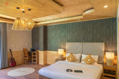 a bedroom with a bed and a desk and a guitar at Zostel Old Manali, Goshal Road in Manāli