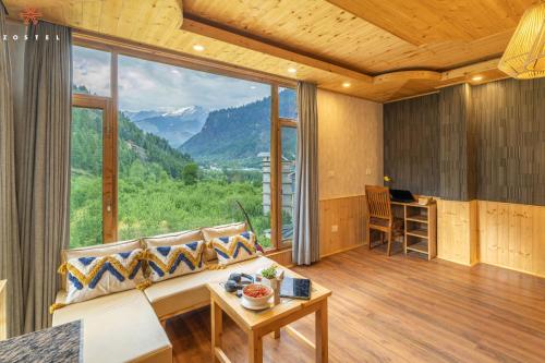 a living room with a couch and a large window at Zostel Old Manali, Goshal Road in Manāli