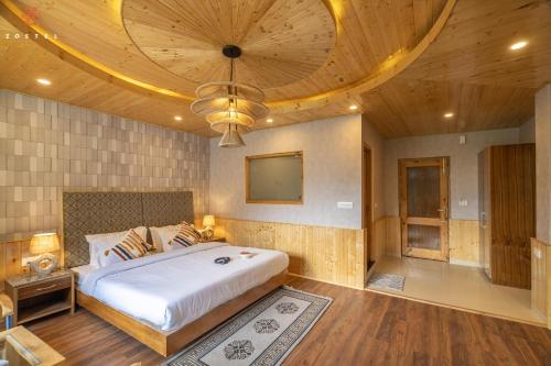 a bedroom with a large bed with a wooden ceiling at Zostel Old Manali, Goshal Road in Manāli