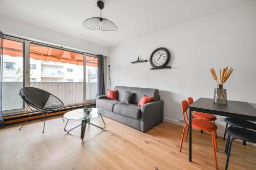 un salon avec un canapé et une table dans l'établissement L’escapade Parisienne - Beau 2 pièces - Proche Paris- Netflix, à Choisy-le-Roi