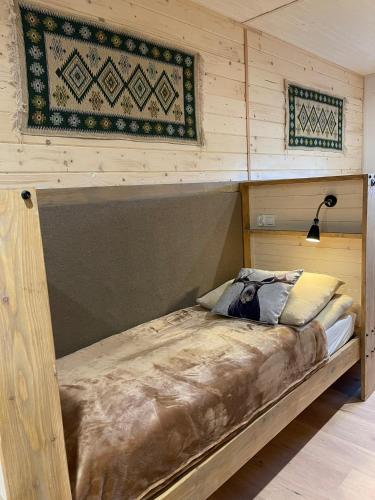 a bed in a room with a wooden wall at Wioska w Sowich Sokolec in Sokolec