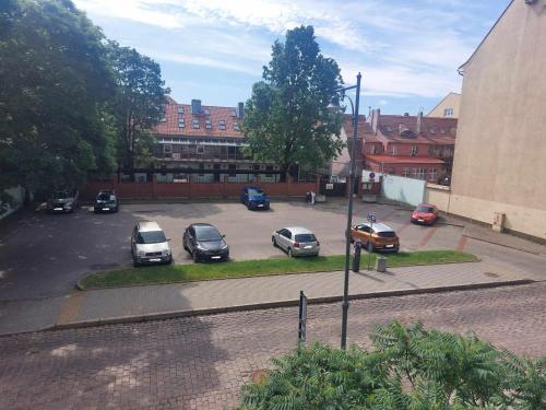 a group of cars parked in a parking lot at Senamiesčio Bangų Apartamentai in Klaipėda