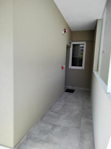 an empty hallway with a window and a tiled floor at SeaEsta Vasiliki 1 in Póndi