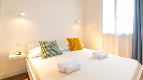 a bedroom with a white bed with towels on it at Ceramic Rooms in Oristano