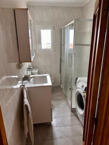 a bathroom with a sink and a washing machine at Miguelón in Bañugues