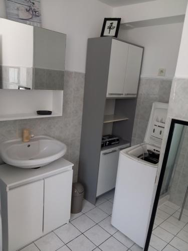 La salle de bains blanche est pourvue d'un lavabo et d'un four micro-ondes. dans l'établissement le gite du baron, à Roz-sur-Couesnon