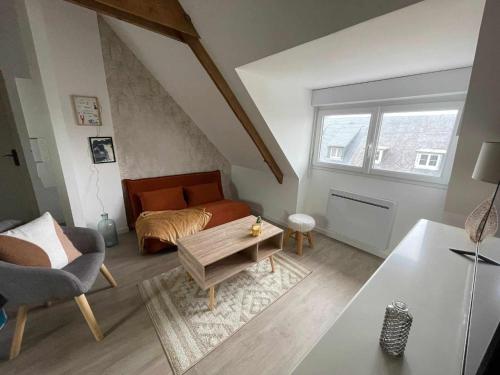 un salon avec un canapé et un lit dans l'établissement Appartement cosy centre ville, à Avranches