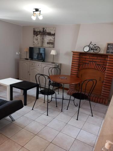 un salon avec une table et des chaises et une cheminée dans l'établissement le gite du baron, à Roz-sur-Couesnon