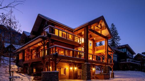 una casa de madera en la nieve por la noche en Lush Mountain Accommodations en Golden