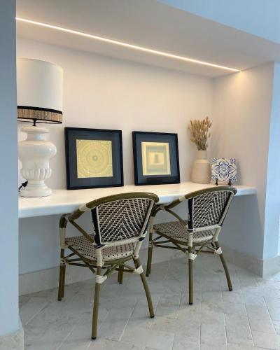 a table with two chairs and two pictures on a wall at Apartamento dúplex con piscina privada en terraza in Alcalá de Guadaira