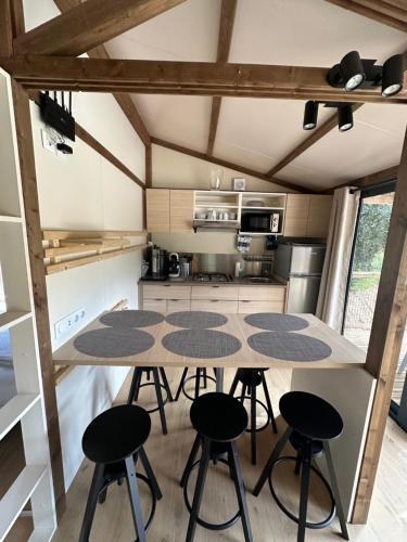 a kitchen with a table and four stools at Le Mas Saint Donat in Sainte-Maxime