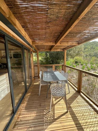 a patio with a table and chairs on a deck at Le Mas Saint Donat in Sainte-Maxime
