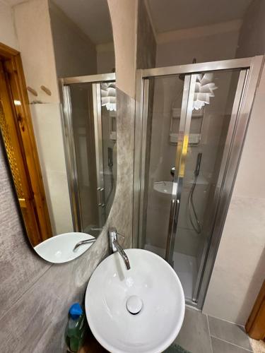 a bathroom with a white sink and a shower at Maison Le Pommier in Morgex