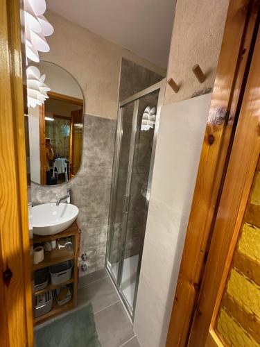 Maison Le Pommier في مورجيكس: حمام مع حوض ومرآة
