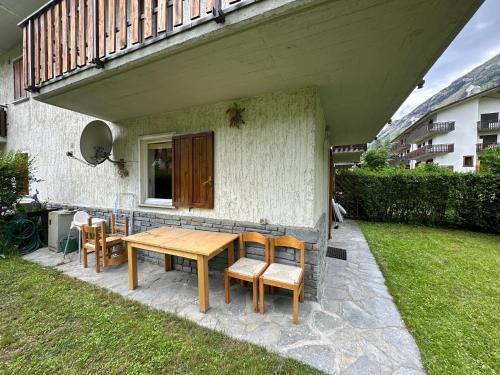 a wooden table and chairs on a patio at Maison Le Pommier in Morgex