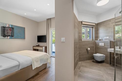 a hotel room with a bed and a bathroom at Villa Iponi in Mimice