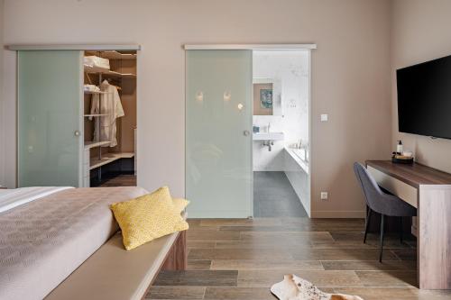 a bedroom with a bed and a desk and a bathroom at Villa Iponi in Mimice
