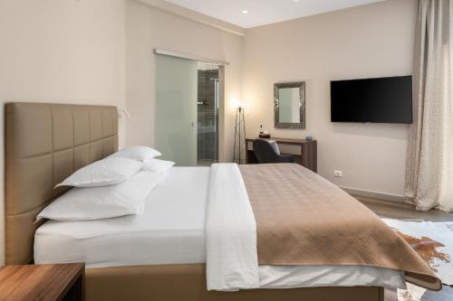 a bedroom with a large bed with a television on the wall at Villa Iponi in Mimice