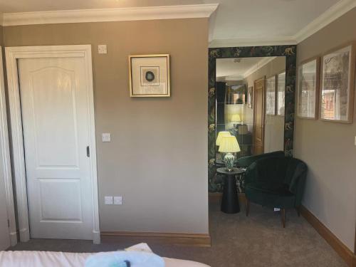 1 dormitorio con espejo, 1 cama y 1 silla en Boutique Shrewsbury Rooms en Shrewsbury