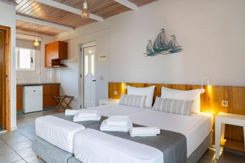 1 dormitorio con 1 cama blanca grande y cocina en Medousa Studio & Apartments, en Plakias