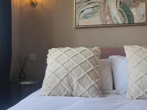 a bed with a pillow and a picture on the wall at Boutique Shrewsbury Rooms in Shrewsbury