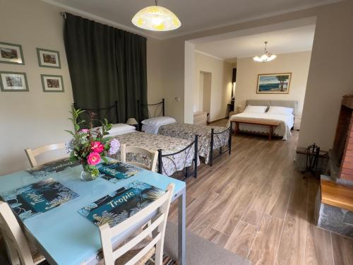 a room with two beds and a table with flowers on it at I Due Ulivi in Calice al Cornoviglio