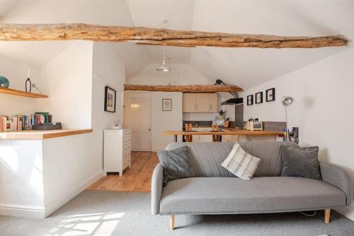 a living room with a couch and a kitchen at Charming flat in lovely rural location in Laneham