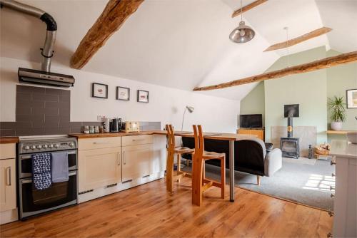 a kitchen and living room with a table and chairs at Charming flat in lovely rural location in Laneham