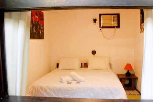 a bedroom with a bed with two towels on it at Pousada Tropicana in Abraão
