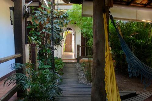 a wooden walkway in a house with plants at Pousada Tropicana in Abraão