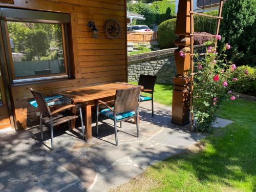 a wooden table and chairs outside of a house at Ferienhaus Schaiter - Ganzes Haus mit Garten und gratis Parkplatz in Innsbruck