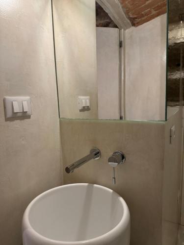 a bathroom with a white toilet and a mirror at Loft n°18 in Arezzo