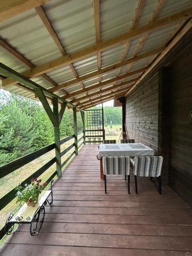 a wooden deck with a table and chairs on it at Agroturystyka u Basi i Waldka in Zelwa