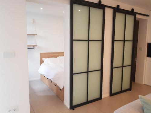 een slaapkamer met een bed met glazen deuren bij Beach House Rodine - free parking & bikes in Scheveningen