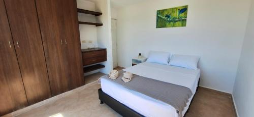 a small bedroom with a bed and a cabinet at EM Somos AT HOME Lindo Apartamento con Aire Acondicionado in Neiva