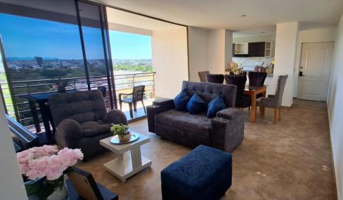 a living room with couches and a table and a kitchen at EM Somos AT HOME Lindo Apartamento con Aire Acondicionado in Neiva