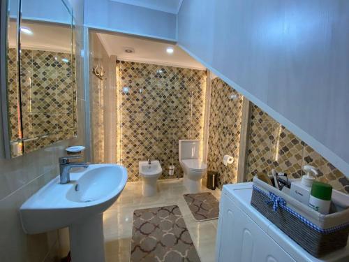a bathroom with a sink and a toilet at Talisman Village House in Bosteri