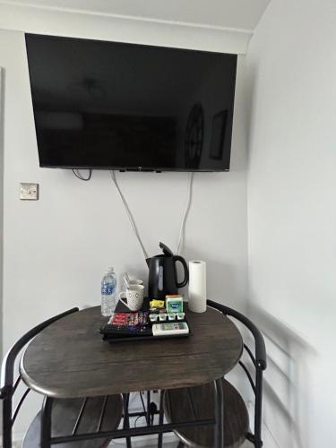 a small table with a tv on a wall at Dana guest suite in Horley
