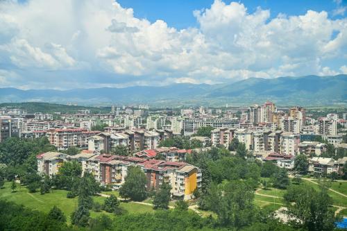 a view of a city with buildings and trees at Portokali Sky Apartment in Skopje