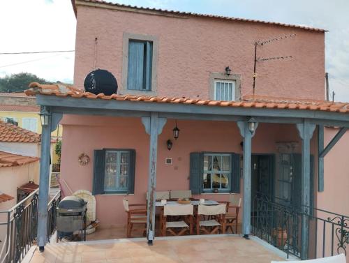 a house with a balcony with a table and chairs at Traditional house at Vasilika, Lesvos in Vasiliká