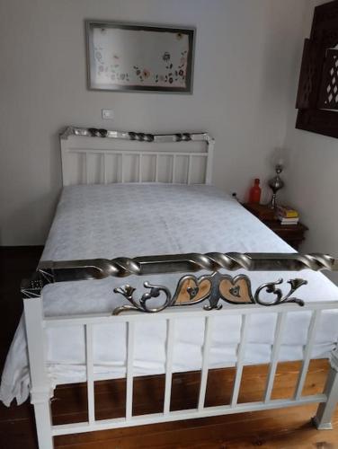 a white bed in a bedroom with a white bed frame at Traditional house at Vasilika, Lesvos in Vasiliká