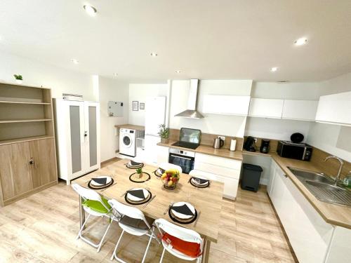 Il comprend une cuisine avec une table et des chaises en bois. dans l'établissement Le Cosy Dunkerquois Centre Ville, à Dunkerque