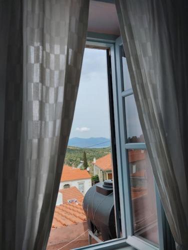 an open window with a view of a house at Traditional house at Vasilika, Lesvos in Vasiliká