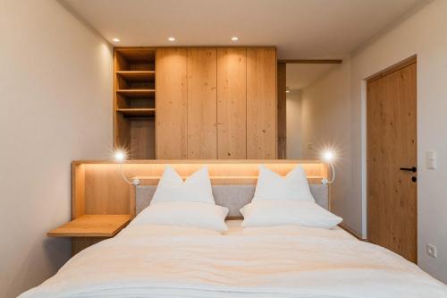 a large white bed with white pillows on it at Valentinerhof Apt Air in San Michele