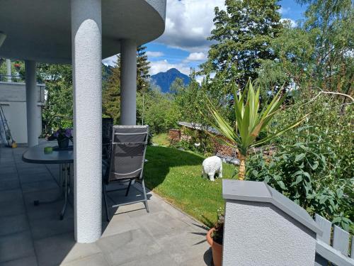 a patio with a table and a sheep in the grass at Ferienwohnung Witting in Wenns