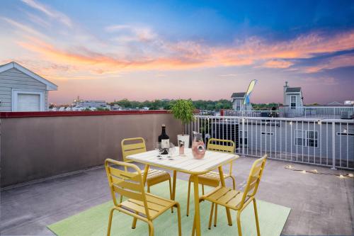 a table and chairs on a balcony with a sunset at New Tropical Island Oasis in Baltimore