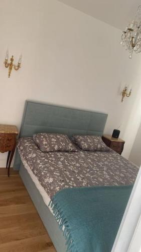 - un lit avec une tête de lit verte dans une chambre dans l'établissement Appart Saint Jean pieds dans l'eau, à Saint-Jean-Cap-Ferrat